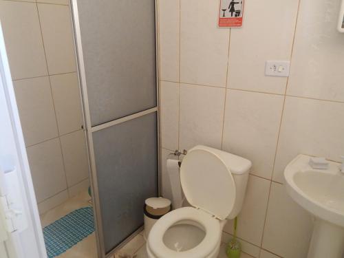 een kleine badkamer met een toilet en een wastafel bij Bangalô Schamaru, in Guaratuba