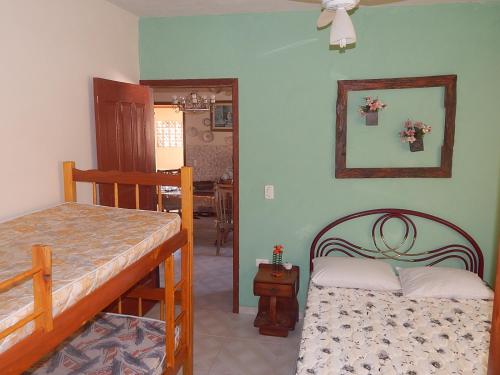 een slaapkamer met een bed en een tafel in een kamer bij Bangalô Schamaru, in Guaratuba