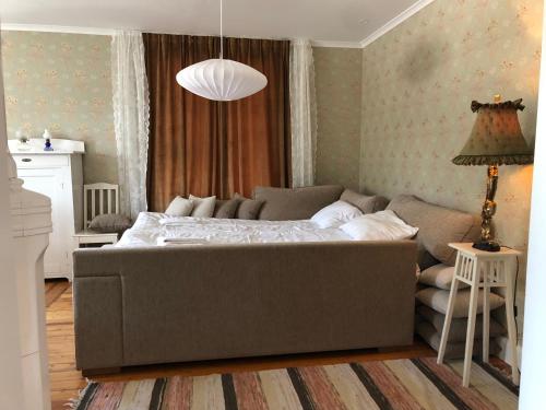 a bedroom with a large bed and a couch at Strandvillan Ljugarn in Ljugarn