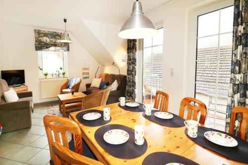 a dining room and living room with a table and chairs at Fewo Sommergarten 4022_CLEM in Ostseebad Karlshagen
