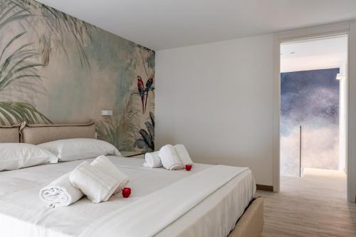 een slaapkamer met 2 bedden, witte handdoeken en een schilderij bij Palermo Blu - Palazzo Quaroni in Palermo