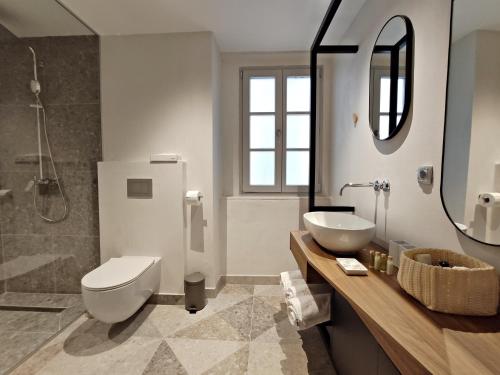 a bathroom with a toilet and a sink and a mirror at Zuviteo Residence in Korčula