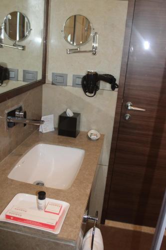 a bathroom with a sink and a mirror at Ramada by Wyndham Gandhidham Shinay in Gandhidham