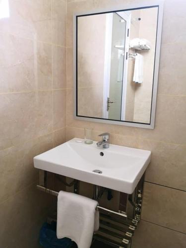 a bathroom with a white sink and a mirror at Walk In Hotel in Kota Kinabalu