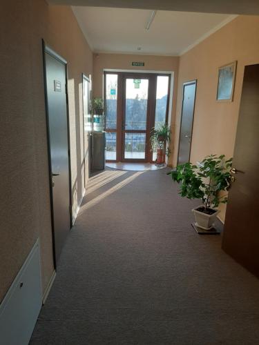 a hallway with doors and potted plants in a building at Stara Vezha Hotel in Boryspilʼ