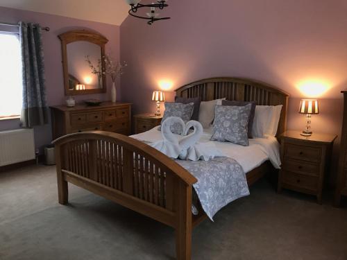 Un dormitorio con una cama con dos cisnes. en Humble Bee Cottage en Folkton