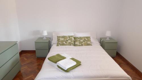 een slaapkamer met een wit bed en 2 nachtkastjes bij Apartamento Vila Nova in Ponta Delgada