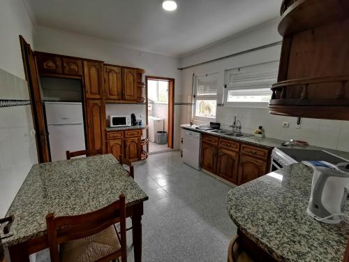 cocina con armarios de madera y encimera en Apartamento Vila Nova, en Ponta Delgada