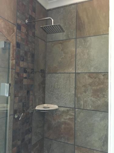 a bathroom with a shower with a glass door at Merry Pebbles Resort in Sabie