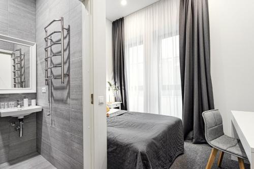 a bedroom with a bed and a sink and a mirror at Kaunas Garden in Kaunas