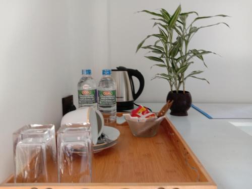 een dienblad met een koffiezetapparaat en een plant op een aanrecht bij 3Arch Eco Cottage Ella in Ella