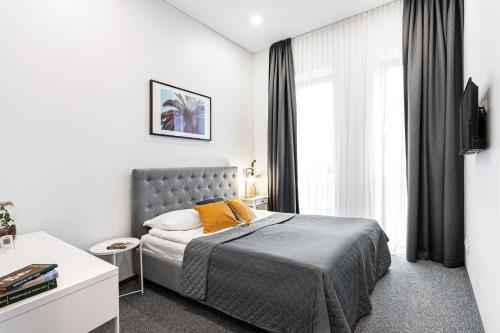 a bedroom with a bed and a large window at Kaunas Garden in Kaunas