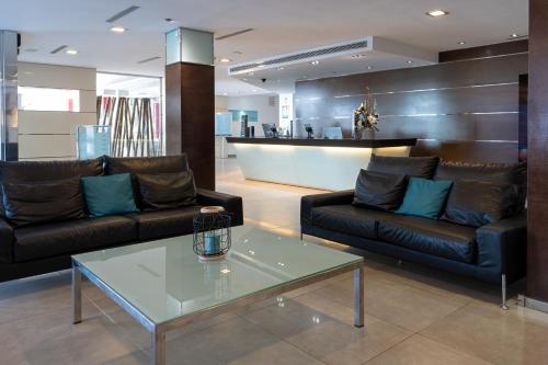 a lobby with two leather couches and a table at Nautic Hotel & Spa in Can Pastilla