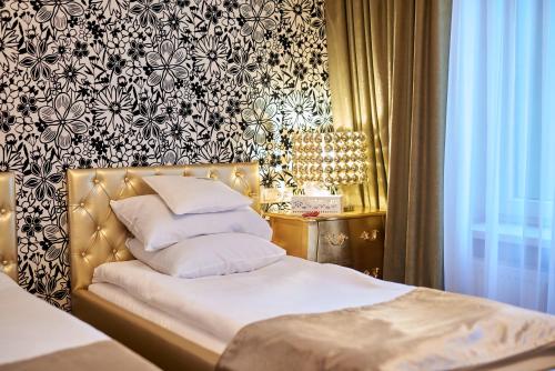 a bedroom with a bed with white pillows and a wallpaper at Weekend Boutique Hotel in Chişinău