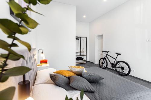 a white couch with pillows and a bike in a room at Kaunas Garden in Kaunas