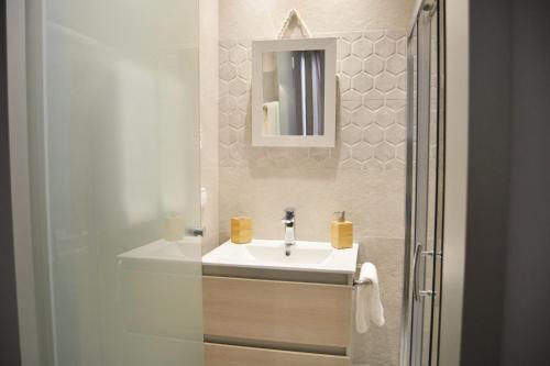 y baño con lavabo blanco y espejo. en Sea House Can Picafort en Can Picafort