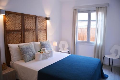 een slaapkamer met een groot bed en een blauwe deken bij Sea House Can Picafort in Can Picafort
