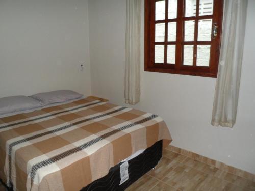 sypialnia z łóżkiem i oknem w obiekcie Lar Doce Mar w mieście Pipa