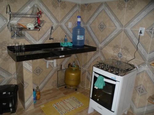 una cocina con fogones y una botella de agua en una encimera en Lar Doce Mar, en Pipa