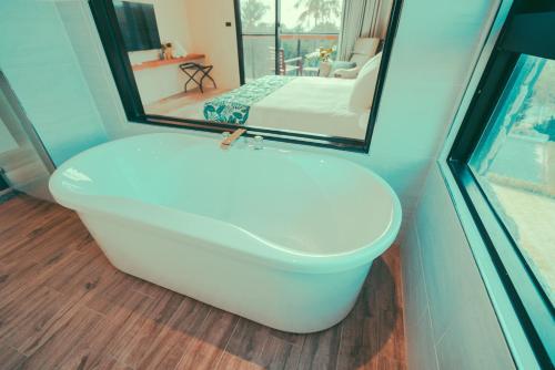 a white bath tub in a room with a mirror at Shark B&B in Hengchun