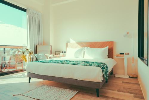 a bedroom with a large bed and a large window at Shark B&B in Hengchun