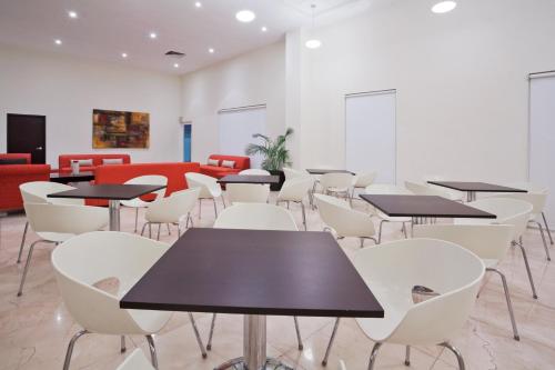 a dining room with tables and white chairs at Holiday Inn Express Ciudad Del Carmen by IHG in Ciudad del Carmen