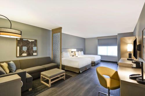 ein Hotelzimmer mit einem Bett und einem Sofa in der Unterkunft Hyatt Place Fresno in Fresno