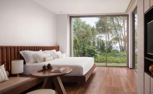 a bedroom with a bed and a large window at Koh Russey Resort in Koh Russey