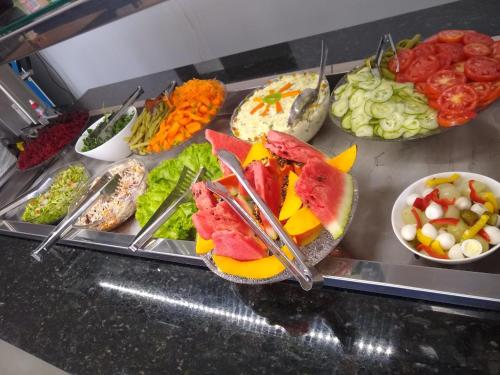 a buffet with a variety of different types of food at Hotel Alvorada - Trindade do Sul in Trindade