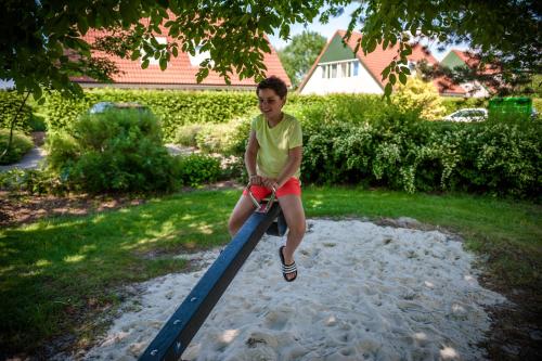 a young boy is sitting on a pole at Hebrechthuis in Vlagtwedde