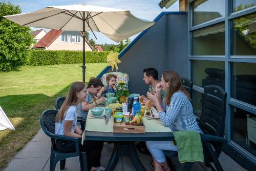 a family sitting at a table eating food at Hebrechthuis in Vlagtwedde