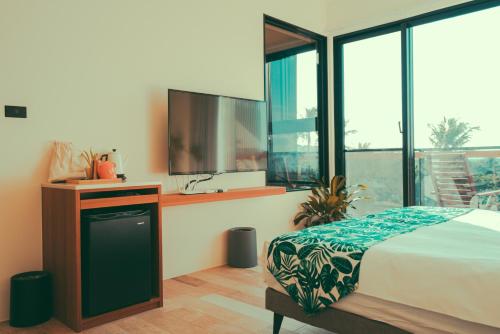 a bedroom with a bed and a tv and windows at Shark B&B in Hengchun