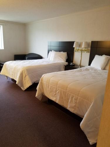 a hotel room with two beds with white sheets at French Creek Inn in Phoenixville