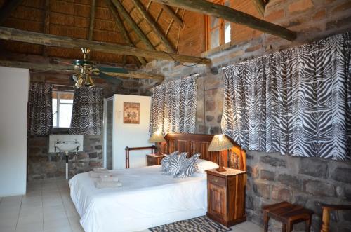 a bedroom with a bed in a stone wall at Seeheim Hotel in Seeheim