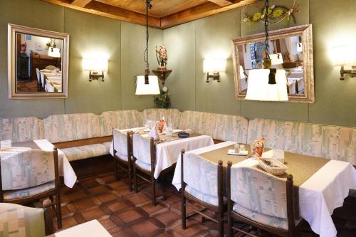 ein Esszimmer mit Tischen, Stühlen und einem Spiegel in der Unterkunft Gasthof & Hotel Goldener Hirsch in Bad Berneck im Fichtelgebirge