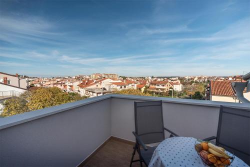 balcón con mesa y vistas a la ciudad en Apartments Val, en Rovinj