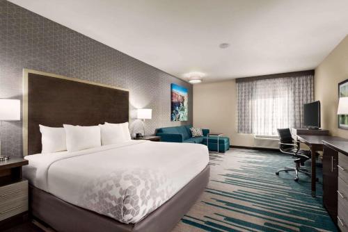 Pokój hotelowy z dużym łóżkiem i biurkiem w obiekcie La Quinta by Wyndham Clovis CA w mieście Clovis