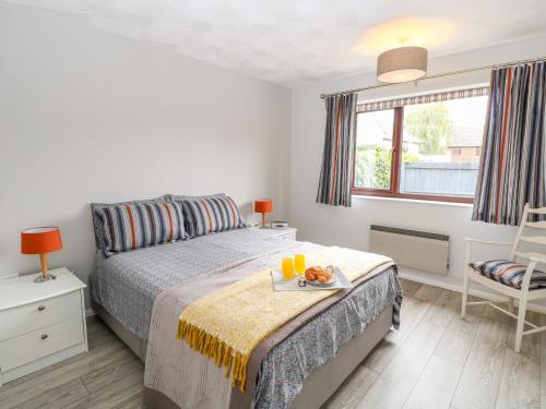 a bedroom with a bed with a tray of food on it at Village Retreat in Ely