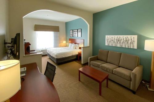 a hotel room with a bed and a couch at Sleep Inn & Suites Pearland - Houston South in Pearland