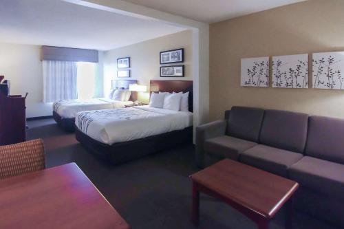 um quarto de hotel com uma cama e um sofá em Wingate by Wyndham Dublin Near Claytor Lake State Park em Dublin