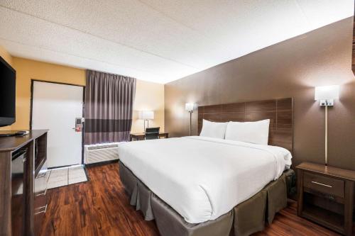 Habitación de hotel con cama grande y TV en Econo Lodge, en Columbus