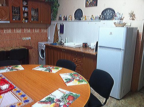 kuchnia ze stołem i lodówką w obiekcie Хостел Тихий дворик w Charkowie