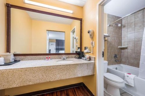 uma casa de banho com um lavatório, um WC e um espelho. em Econo Lodge em Columbus