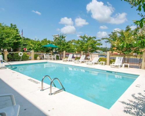 a large swimming pool with chairs and a umbrella at Comfort Inn in Shelby