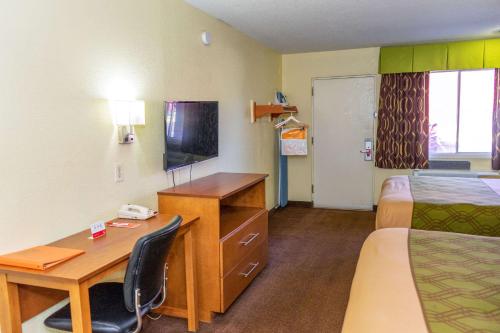 a hotel room with a desk and a bed and a room at Econo Lodge Weldon - Roanoke Rapids in Weldon