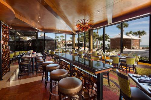 a restaurant with a bar with chairs and tables at Holiday Inn Resort Galveston - On The Beach by IHG in Galveston
