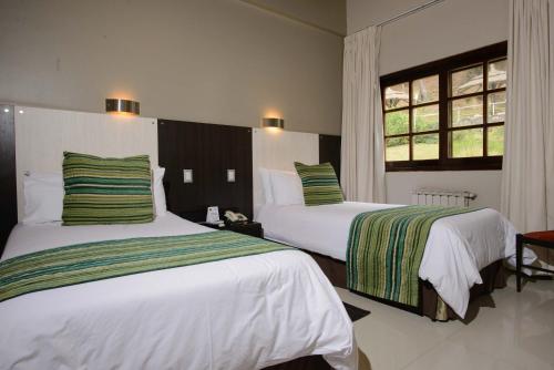 Habitación de hotel con 2 camas y ventana en Portezuelo Hotel en Salta