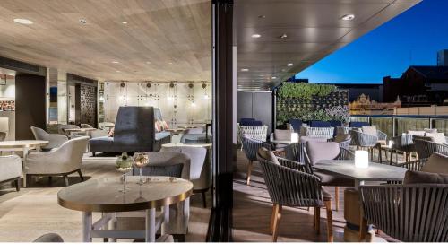 a restaurant with tables and chairs with a view at InterContinental Perth City Centre by IHG in Perth