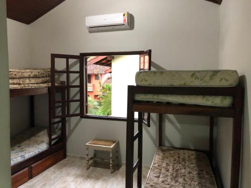 a room with three bunk beds and a window at Casa de Praia Riviera de Sao Lourenco - Vilagio in Bertioga