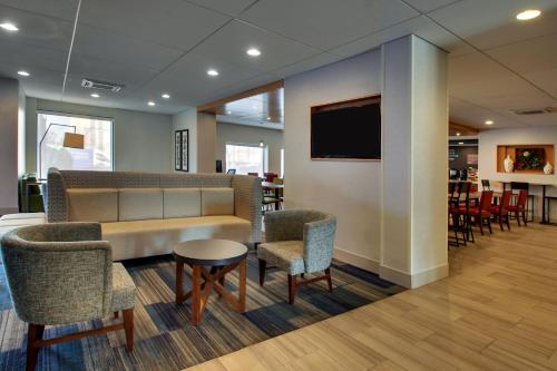 a waiting room with a couch and chairs and a tv at Holiday Inn Express Baltimore BWI Airport West by IHG in Hanover